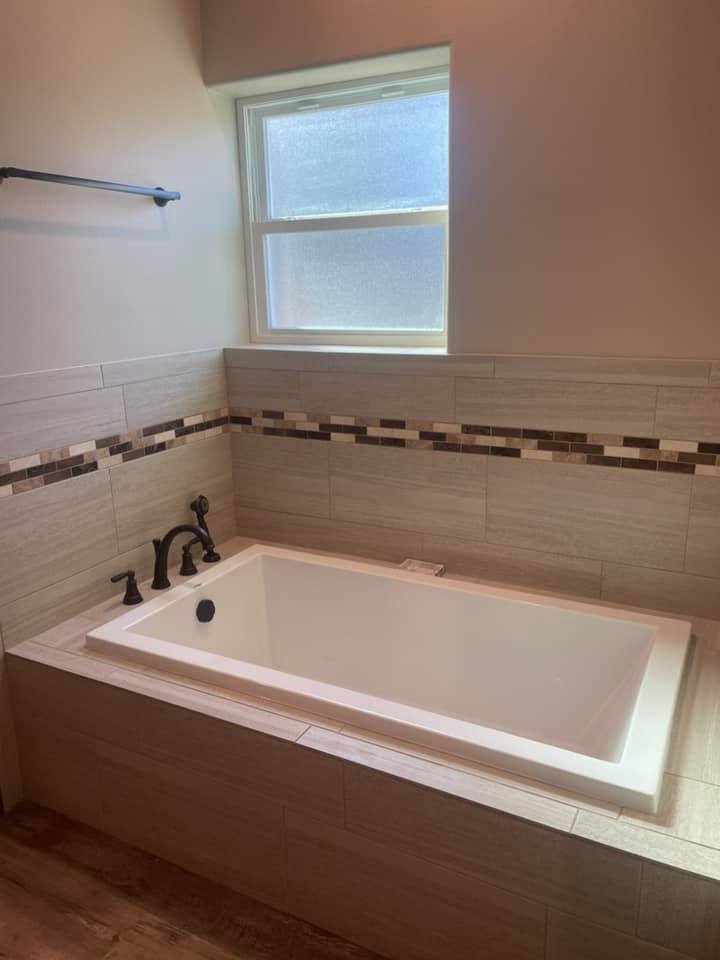 Tiled tub surround with mosaic accent border installed in Brownwood TX by Heart of Texas Flooring